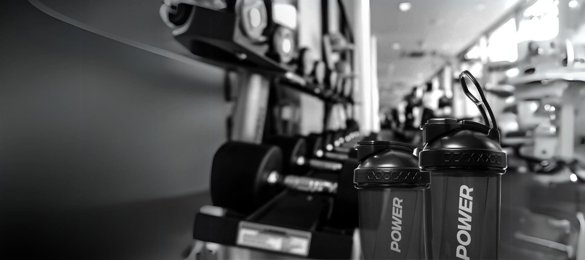 A row of power shaker bottle lined up on a gym counter, ready for use during workouts.